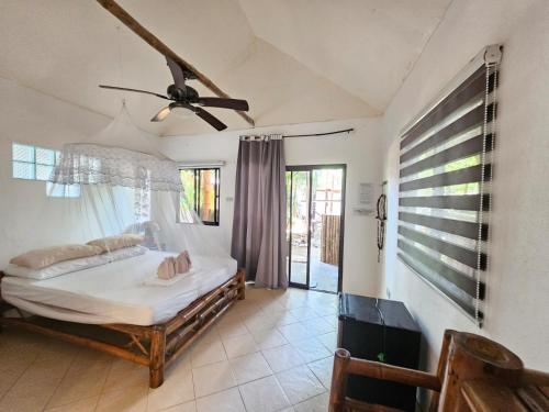 a bedroom with a bed and a ceiling fan at Big BamBoo Beach Resort Sipalay in Sipalay