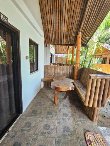 a porch with a bench and a table at Big BamBoo Beach Resort Sipalay in Sipalay