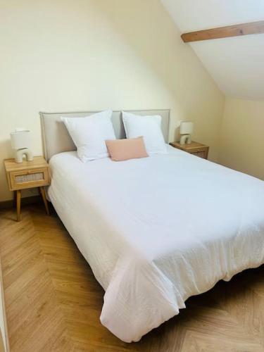 une chambre avec un grand lit blanc avec deux tables de nuit dans l'établissement Le Cocon, à Braux