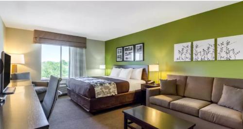 a hotel room with a bed and a couch at Sleep Inn & Suites in Pleasanton