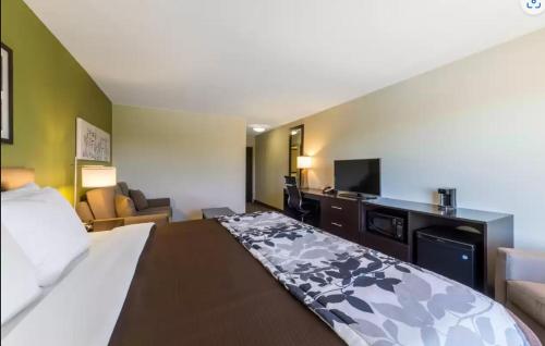 a hotel room with a bed and a flat screen tv at Sleep Inn & Suites in Pleasanton