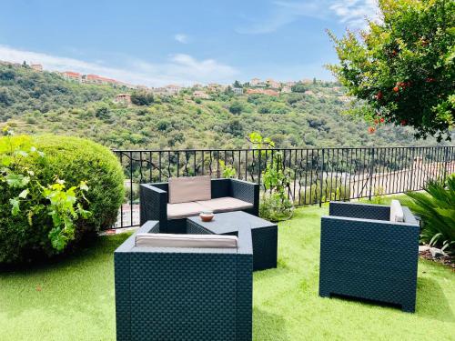 un jardin avec deux chaises et un banc sur la pelouse dans l'établissement Nissa la bella, Piscine et vue mer, à Nice