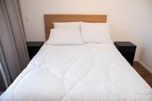 a large white bed with white sheets and pillows at ST Studios Vila Mariana by Housi in Sao Paulo