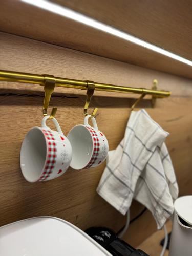 a group of coffee cups hanging on a wall at Mona Luxury Apartments - Free Garage Parking in Sarajevo