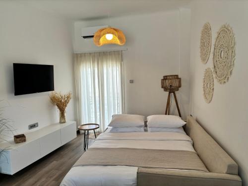 a bedroom with two beds and a flat screen tv at Cerro Fine Living in Ermoupoli