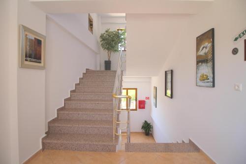 a staircase in a home with white walls and a ladder at Hotel Milo Ksamil in Ksamil