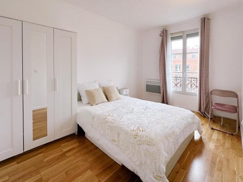 une chambre blanche avec un grand lit et une fenêtre dans l'établissement Paris center 2 rooms appt metro 14 Olympiades, à Paris