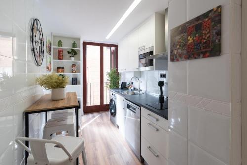 a kitchen with white appliances and a table and a chair at Albada Huesca in Huesca