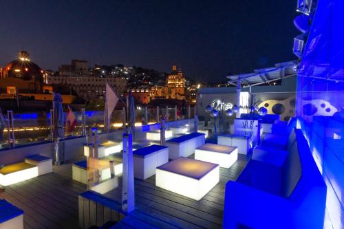 a rooftop deck with couches and lights at night at 1850 Hotel Boutique in Guanajuato