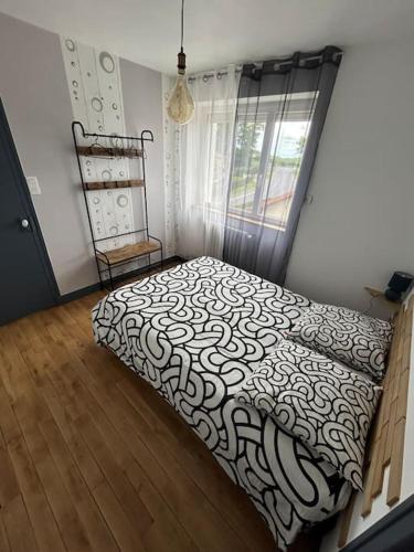 une chambre avec un lit avec une couette noire et blanche dans l'établissement Maison le Ragean, à Lafeuillade-en-Vézie
