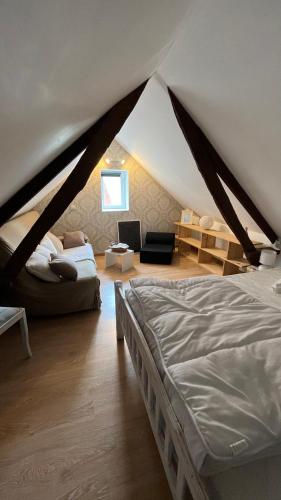 - une chambre avec un lit et un canapé dans une tente dans l'établissement Maisonnette calme, à Balleroy