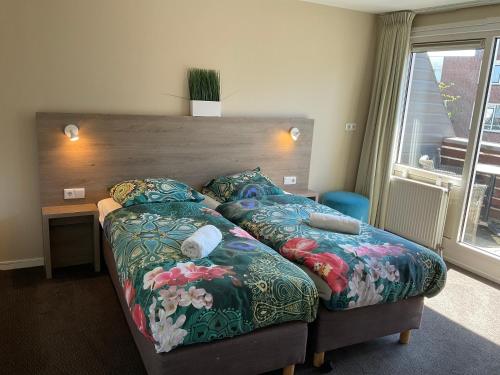 a bedroom with a bed and a desk and a window at Fisherman's House by Hofstad Hotels in Scheveningen