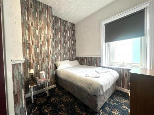 a small bedroom with a bed and a window at Tower Central hotel Albert Road in Blackpool