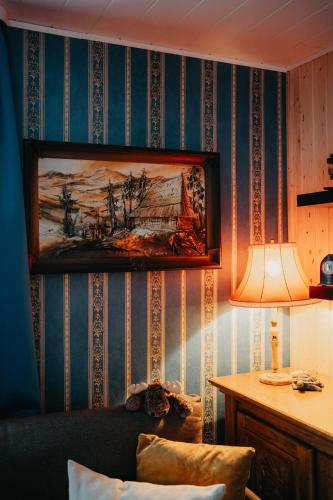 a living room with a painting on the wall at Altes Häusle am Waschbach Anno 1625 Ferienwohnungen und Doppelzimmer in Edenkoben