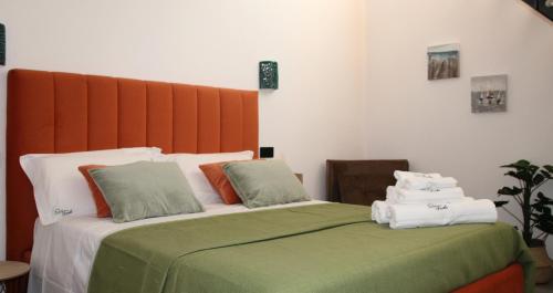a bed with green and white sheets and pillows at Frida Luxury B&B in Vietri sul Mare