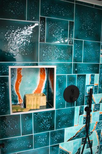 a room with a blue tiled wall with a picture at Frida Luxury B&B in Vietri sul Mare