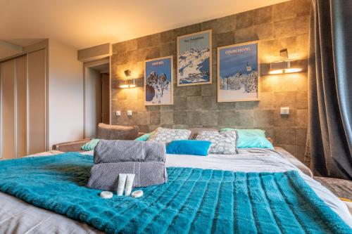 une chambre avec un grand lit avec une couverture bleue dans l'établissement Ski In-Out - Heart of Val Thorens Spacious 8 Guests Apartment, WiFi 303, à Val Thorens