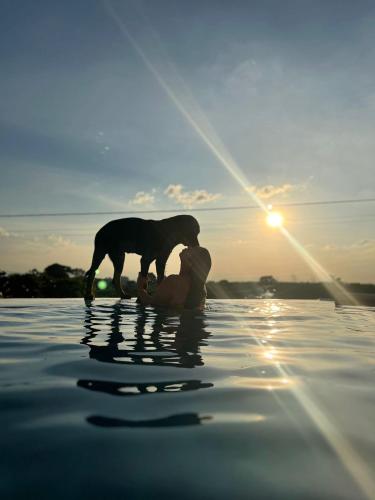 a woman and a dog standing in the water at Castillo Del Toro in Armenia