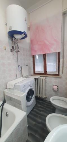 a bathroom with a washing machine and a washer at CasaMarea in Grottammare