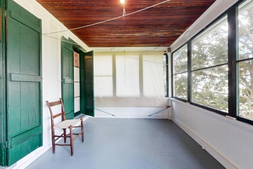 eine leere Veranda mit einem Stuhl und Fenstern in der Unterkunft Seneca Vintage in Rock Stream