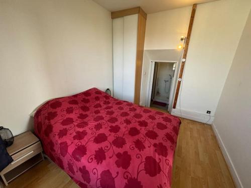 - une chambre dotée d'un couvre-lit rouge et de fleurs dans l'établissement Modern house CDG Astérix JO, à La Chapelle-en-Serval