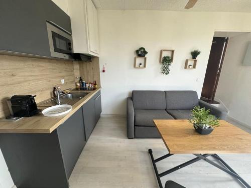 une cuisine avec un évier et un canapé dans une chambre dans l'établissement Modern house CDG Astérix JO, à La Chapelle-en-Serval