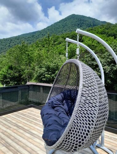 a blue sleeping bag in a hammock on a deck at Qafqaz Mountain Terrace İndoor Hot Pool in Gabala