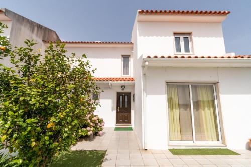a white house with a door and a courtyard at Nazare with Garden and Barbecue in Nazaré
