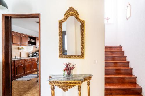 a hallway with a mirror and a table and stairs at Nazare with Garden and Barbecue in Nazaré