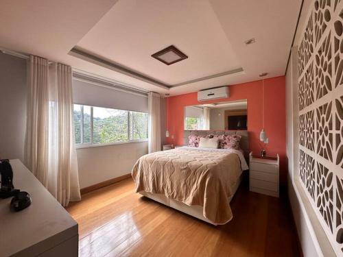 a bedroom with a large bed and a large window at Luxo e conforto a 15 minutos do centro de Petrópolis in Petrópolis