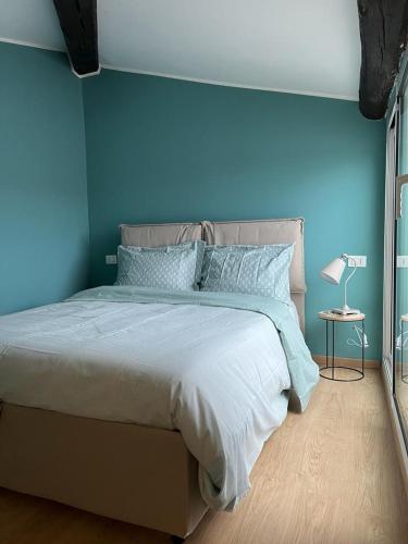 a blue bedroom with a bed with a blue wall at La terrazzina OLTRE HOME HOLIDAYS in Sanremo