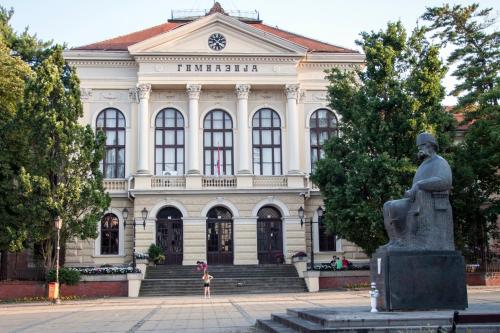 a large building with a statue in front of it at Apartman Erdoglija in Kragujevac