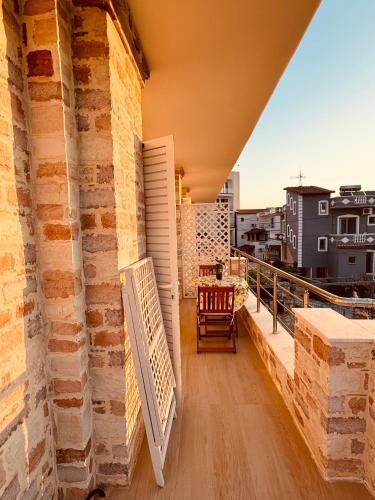 a balcony with a table and a chair on a building at Orfeu apartments Ksamil in Ksamil