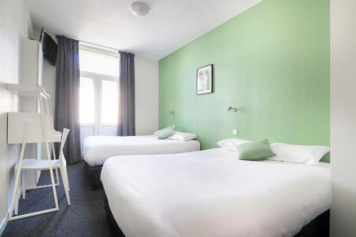 deux lits dans une chambre aux murs verts dans l'établissement La Rotonde, à Saint-Malo