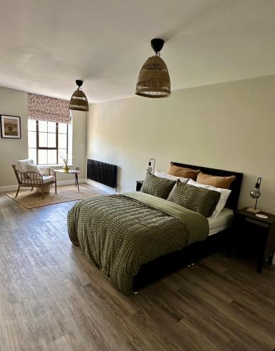 a bedroom with a large bed and two pendant lights at Raleigh Waterside apartment - The Barbican, Plymouth in Plymouth