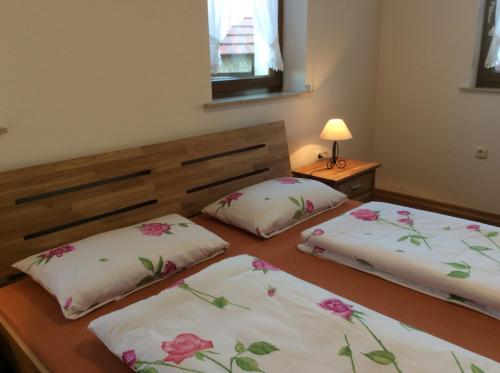 two beds in a room with flowers on them at Atelier Reinhart in Rauhenebrach