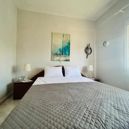 a bedroom with a large bed with two lamps at Next to the Beach Apartments , Delta Hospitality in Ofrínion