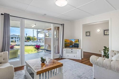 a living room with a couch and a tv at Warm and Cozy Cottage House in Gympie