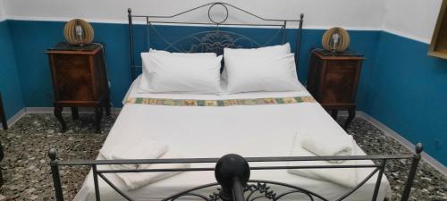 sypialnia z łóżkiem z białą pościelą i 2 szafkami nocnymi w obiekcie Studio Room Pasilong Vacanza nel Salento w mieście Soleto