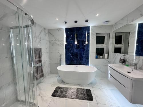 ein Badezimmer mit Badewanne, Dusche und Waschbecken in der Unterkunft 1 Orchard Farm Cottages Sleeps 10, Open plan Kitchen & Large Garden in East Grinstead