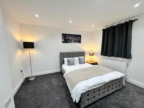 ein Schlafzimmer mit großem Bett und Fenster in der Unterkunft 1 Orchard Farm Cottages Sleeps 10, Open plan Kitchen & Large Garden in East Grinstead