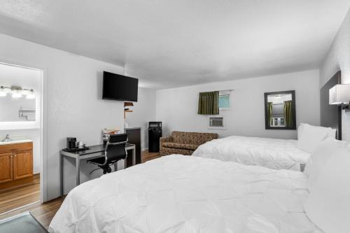 a hotel room with two beds and a desk at Americas Best Value Inn Jonesville/Hillsdale in Jonesville