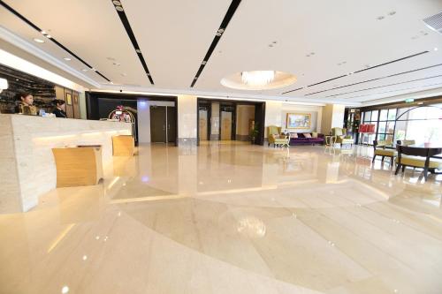 a lobby with a marble floor and tables and chairs at Grand Earl Hotel in Douliu