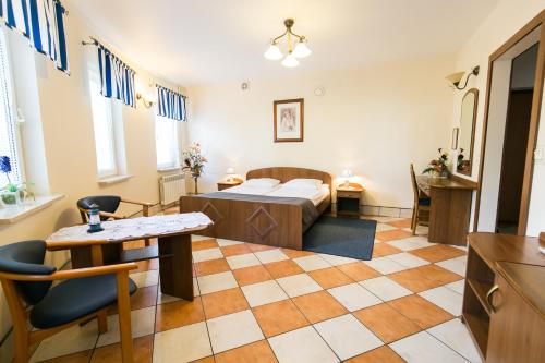 a room with a bed and a table and chairs at Gościniec pod Żaglami in Skoki Duże