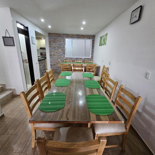 a dining room with a long table and wooden chairs at Casa vacacional Estadía Primaveral in Fusagasuga