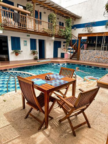 a table and two chairs next to a swimming pool at Casa del Puerto Hostel & Suites in Cartagena de Indias