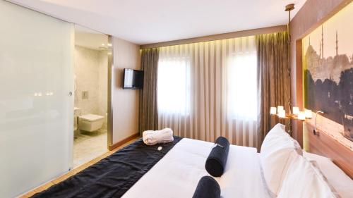 a bedroom with a large bed and a bathroom at Hotel Saint Sophia in Istanbul