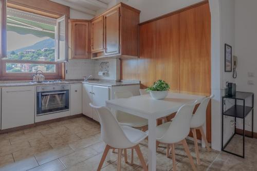 a kitchen with a white table and white chairs at Casa Breggia in Cernobbio