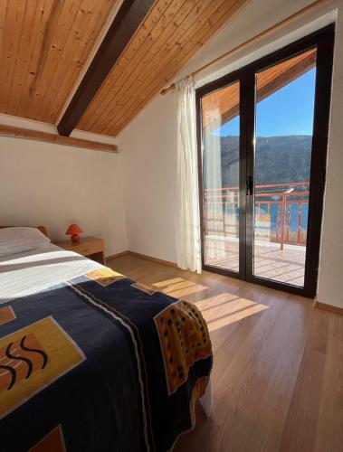 ein Schlafzimmer mit einem Bett und einer großen Glasschiebetür in der Unterkunft SunsetBeach in Grebaštica