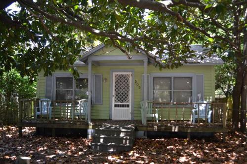 a small green house with chairs on the porch at Beaufort Harbour Suites East Lodge in Beaufort